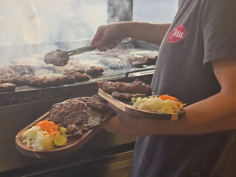 Pjatë zgare me sallatë të freskët dhe garniturë, gati për servirje